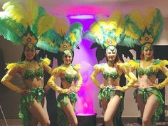 three women in green and yellow costumes standing next to each other with their hands on their hips