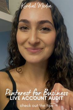 a woman with long curly hair smiles at the camera and has her hand in her pocket