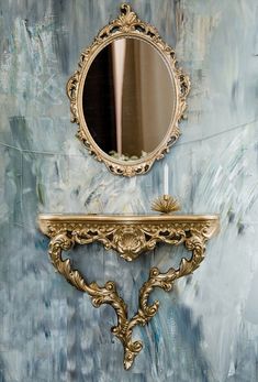 a mirror and shelf in front of a blue wall