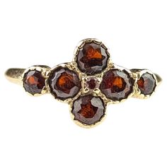 An interesting and pretty vintage Garnet cluster ring. It has a rich yellow gold mount with an array of bezel set rich red garnets with a tiny prong set stone to the very centre if the arrangement. There are seven round cut garnets in total and the ring has an older look to it with the bezel settings. The ring has smooth yellow gold shoulders and a smooth slender band. Marks and era: Fully hallmarked for 9ct gold, London Assay office, 1986. Condition: Good used condition overall, some age commensurate surface wear and signs of use, stones with some scratches and small nibbles. UK/AU ring size J½ US ring size 5 MM ring size 49.32 Total weight 1.54 grams Approx 8mm length ring Face and 1.7mm band width. The ring does not come boxed it is shown in the images boxed for display purposes only. G Vintage Cluster Ring, Brilliant Earth Rings, Precious Jewels, Garnet Jewelry, Antique Engagement Rings, Brilliant Earth, Online Wedding, Planning Ideas, I Love Jewelry