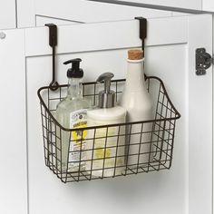 a basket hanging on the side of a door with soap and lotion in it