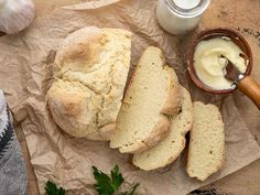 a loaf of bread sitting on top of a piece of paper next to a bowl of butter