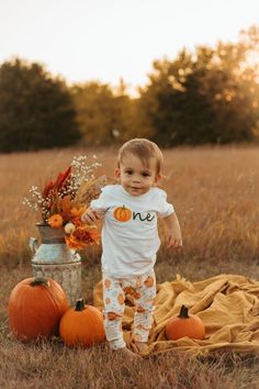 a toddler standing in a field with pumpkins