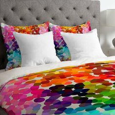 a bed with colorful sheets and pillows on it