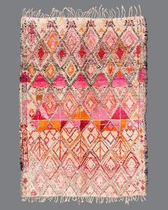 an old rug with many different colors and patterns on it, including red, pink, orange