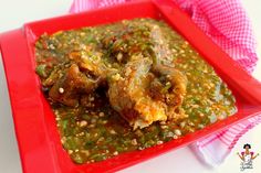 a red plate topped with meat covered in green sauce