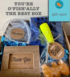 a box filled with blue and yellow candies next to a sign that says thank you're offishaally the best box