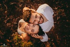 a man and woman are laying on the ground together, looking up at the camera