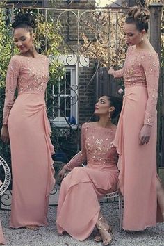 three women in pink dresses standing next to each other and one is sitting on the ground