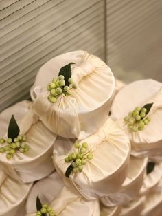 a pile of white hats with green flowers on them