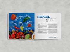 an open book with pictures of peppers and other vegetables on it's cover, sitting on a gray surface