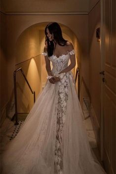 a woman in a wedding dress standing on the stairs