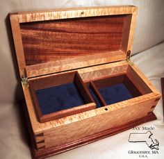 an open wooden box with two compartments on the inside and blue velvet linings in it