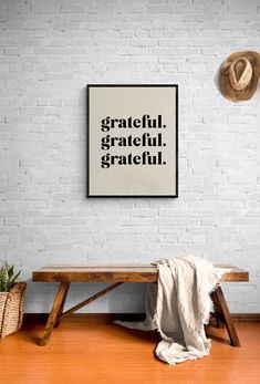 a white brick wall with a wooden bench and hat hanging on it's side