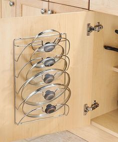 a kitchen cabinet door is open to reveal a wine rack with six glasses on it