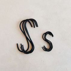 the letters s and s are made out of black plastic strips on a white surface