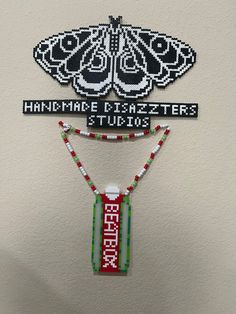 two pieces of beaded art hanging on the wall next to each other with words written across them