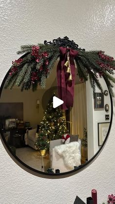 a mirror hanging on the wall above a christmas tree