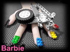 a woman's hand with colorful legos on it and the word barbie written below