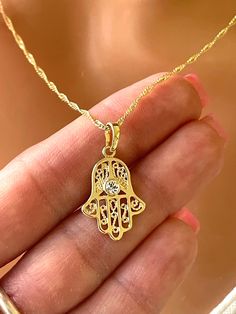 This is a beautiful 14 karat gold filled Hamsa charm necklace for women. This beautiful hamsa charm features a CZ center, measures 22 x 15 mm and comes on a 14 K gold filled Singapore chain. This beautiful chain is shiny and sparkles, has a lobster clasp in back. Chain length is 18 inches.  You also have the option to choose a 20 inch length, which will be 18 to 20 inch adjustable. Comes in a gift box ready to present. Hamsa Necklace Gold, Hand Pendant, Hamsa Charm, Gold Hamsa, Hamsa Necklace, Charm Necklaces, Necklace Women, Necklace Gift, Gift For Mom