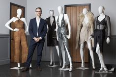 a man standing next to some mannequins wearing clothes