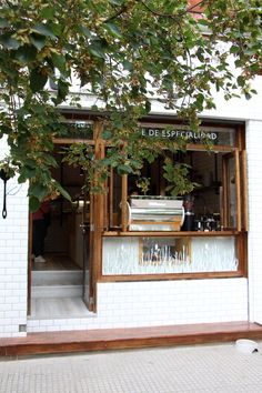 the outside of a building with an open window and plants growing out of it's windows