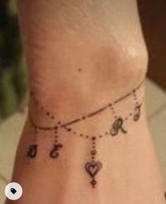 a small wrist tattoo with hearts and keys on it