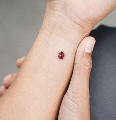 a ladybug tattoo on the left wrist