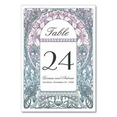 a wedding table number card with an ornate frame and floral design in green, gold and white