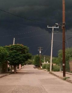 storm clouds loom in the sky over an empty street