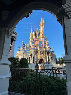 the entrance to disneyland's castle is seen through an arch in front of it