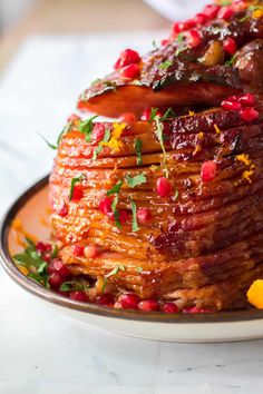 a large stack of pancakes covered in fruit and garnished with pomegranates