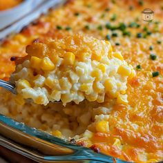 a spoon full of macaroni and cheese being lifted from a casserole dish