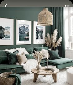 a living room with green walls and pictures on the wall above the couch, coffee table