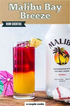 a colorful drink next to a bottle of malbu bay breeze