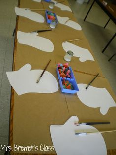 the table is set up with paper cutouts and scissors to make masks for children