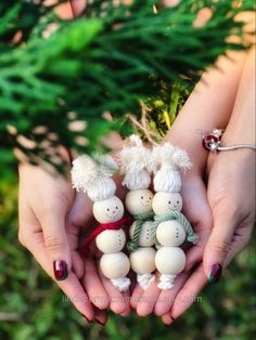 two hands are holding small snowmen in their palms