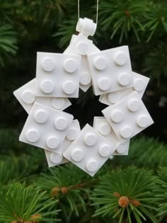 a christmas ornament made out of legos is hanging from a pine tree