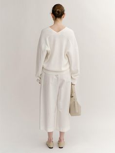 The oversized knit pullover. Featuring the deep V-neckline, drop shoulder design, and oversized silhouette. The soft color, basic details, and relaxed fit are accentuated. - Deep V-neckline and drop shoulder design- Oversized silhouette and cropped length- Ribbed trim at sleeves and hem- Both basic and feminine mood Oversized V-neck Cardigan With Ribbed Cuffs, Oversized V-neck Sweater With Ribbed Cuffs, Oversized Chic V-neck Sweater, Oversized V-neck Chic Sweater, Oversized V-neck Sweater For Loungewear, Chic Oversized V-neck Sweater For Loungewear, V-neck Sweater For Loungewear, Chic Oversized V-neck Sweater, Relaxed Fit V-neck Knit Top For Work