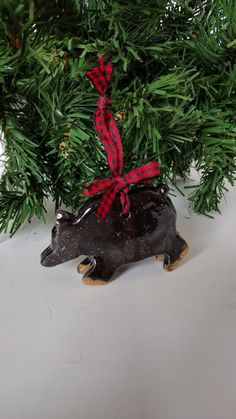 a black bear ornament with a red ribbon tied around it's neck