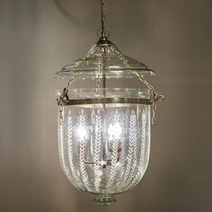 a glass light fixture hanging from the ceiling