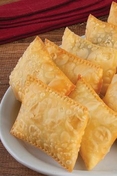 some food is on a white plate and sits on a brown tablecloth next to a red towel