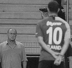 black and white photograph of two men standing in front of a man holding a camera