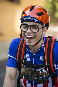 a man wearing glasses and a helmet smiles for the camera