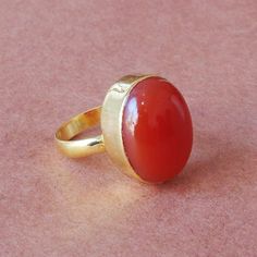 Handmade with love our artisan have use age old Indian technique to give this ring a flawless finish. Made entirely from brass we have used a vibrant red onyx to complete the look. Red onyx symbolizes the fire element and radiates energy. It will be the ideal gift to surprise your mother this wonderful statement ring. Product Details Item Code: BJBR-0337 Stone Name: Red Onyx Metal: 18K Yellow Gold Plated Over Brass Ring Sizes: Please choose from the drop-down menu. If you do not see your finger Gold Ring With Large Stone As Gift, Brass Rings With Polished Finish As Gift, Brass Rings With Polished Finish For Gift, Oval Brass Gemstone Ring, Red Carnelian Ring As A Gift, Yellow Gold Rings With Large Stone As Gift, Yellow Gold Ring With Large Stone For Gift, Formal Handmade Brass Ring, Red Carnelian Wedding Rings