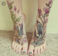 a woman's legs with tattoos and flowers on them