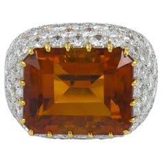 This exquisite cocktail ring, crafted by Tiffany & Co. in the 1980s, showcases a stunning emerald-cut citrine stone at its heart. The citrine, measuring 14.43mm x 11.56mm, radiates a warm, golden hue that captures the light beautifully. Surrounding the central gem, a halo of round pave diamonds adds a touch of brilliance and elegance. Set in platinum, the ring has a substantial gross weight of 10.10 grams, ensuring a luxurious feel. This size 5.5 ring is a timeless piece, embodying the sophistic Orange Jewelry, Tiffany Diamond, Vintage Cocktail Ring, Diamond Cocktail Ring, Brown Jewelry, Contemporary Ring, Diamond Cocktail Rings, Platinum Engagement Rings, Sapphire Diamond Ring