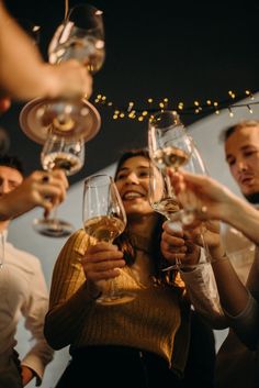 a group of people toasting with wine glasses