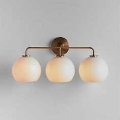 three light bathroom fixture in an antique brass finish with frosted glass globe shade shades