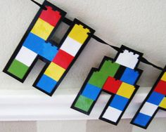 some legos are hanging on a line in a room with white walls and striped wallpaper